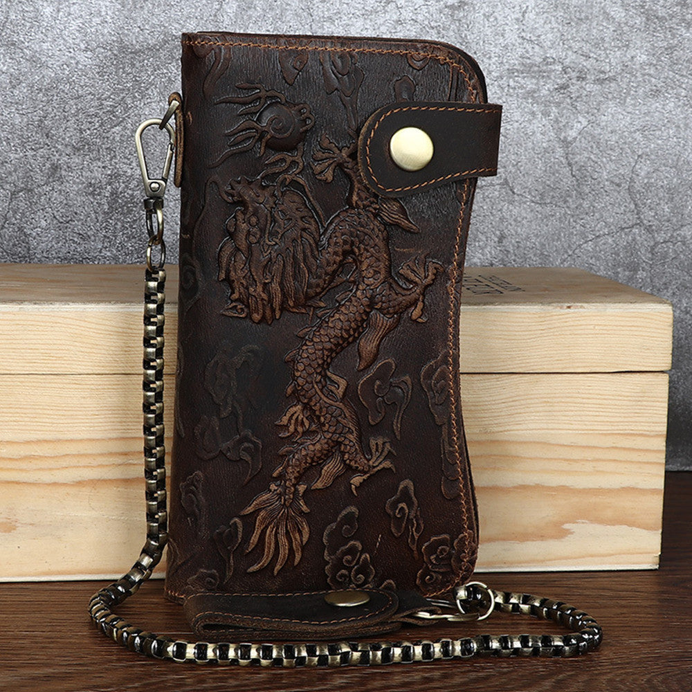 Brown leather wallet with dragon design on a wooden surface