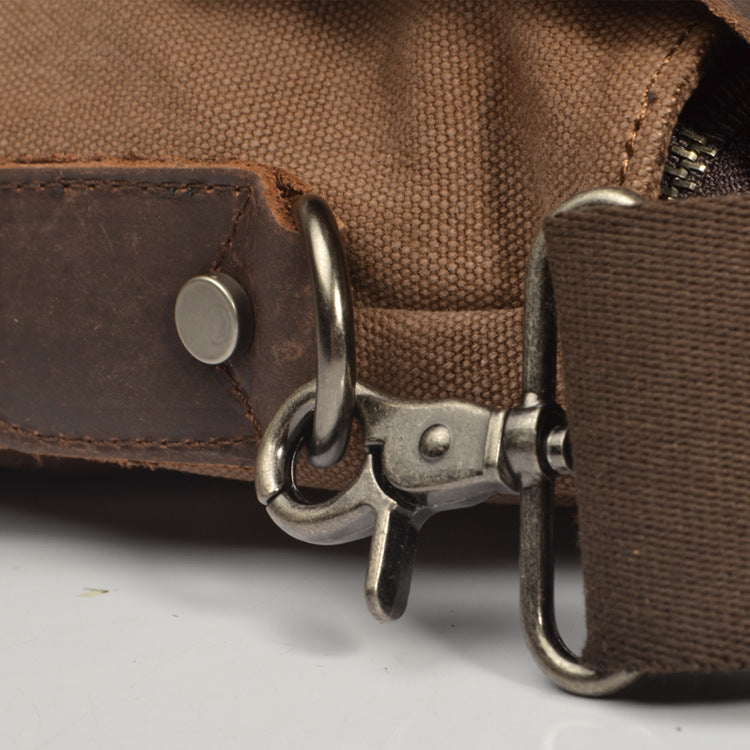 Close-up of a brown leather bag with metal buckle on a light gray background