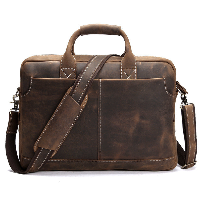 Brown leather briefcase with shoulder strap on a white background
