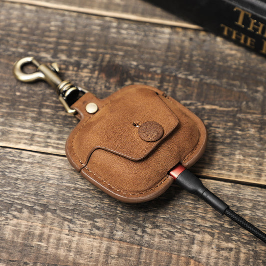 Brown leather keychain with a strap on a wooden surface