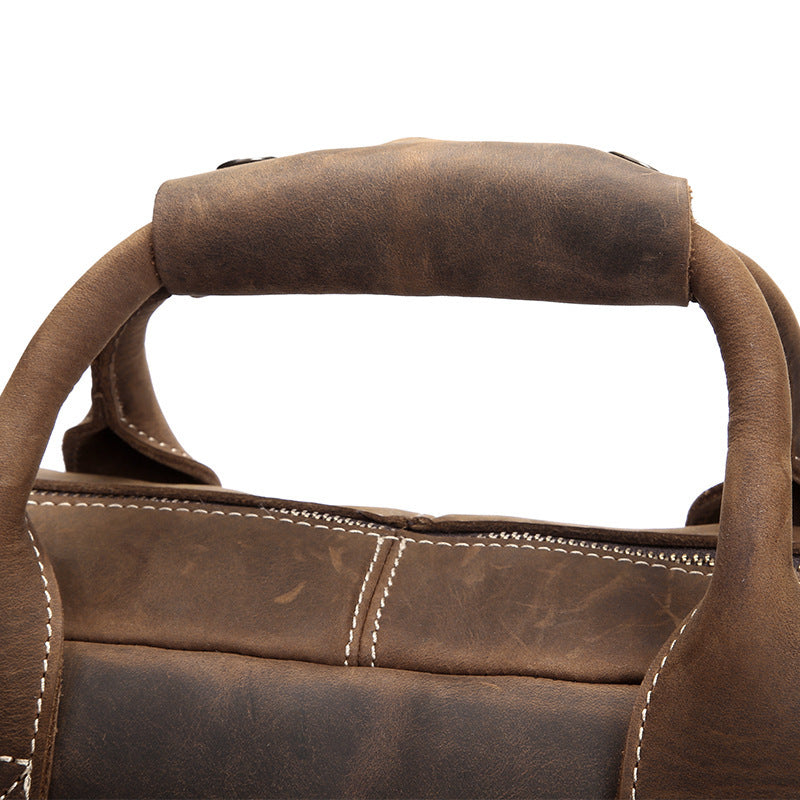 Close-up of a brown leather bag with handles on a white background