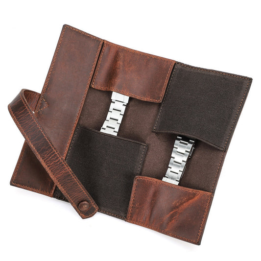 Brown leather watch case with silver watch and strap on a white background