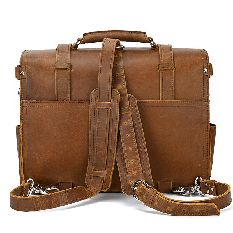Brown leather briefcase with shoulder strap on a white background