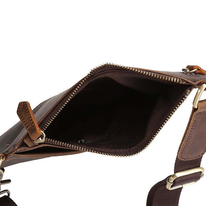 Brown leather crossbody bag with gold zipper and strap on a white background