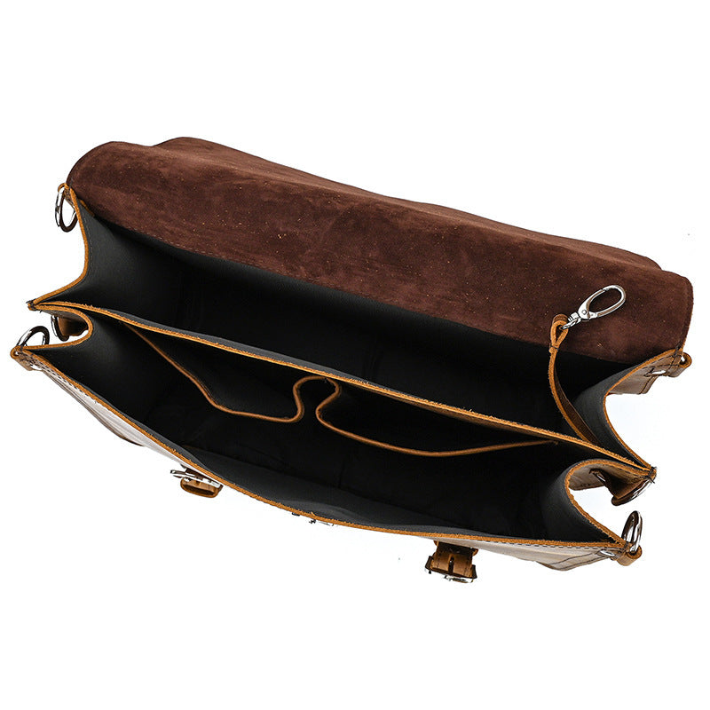 Brown leather clutch bag with black interior on a white background
