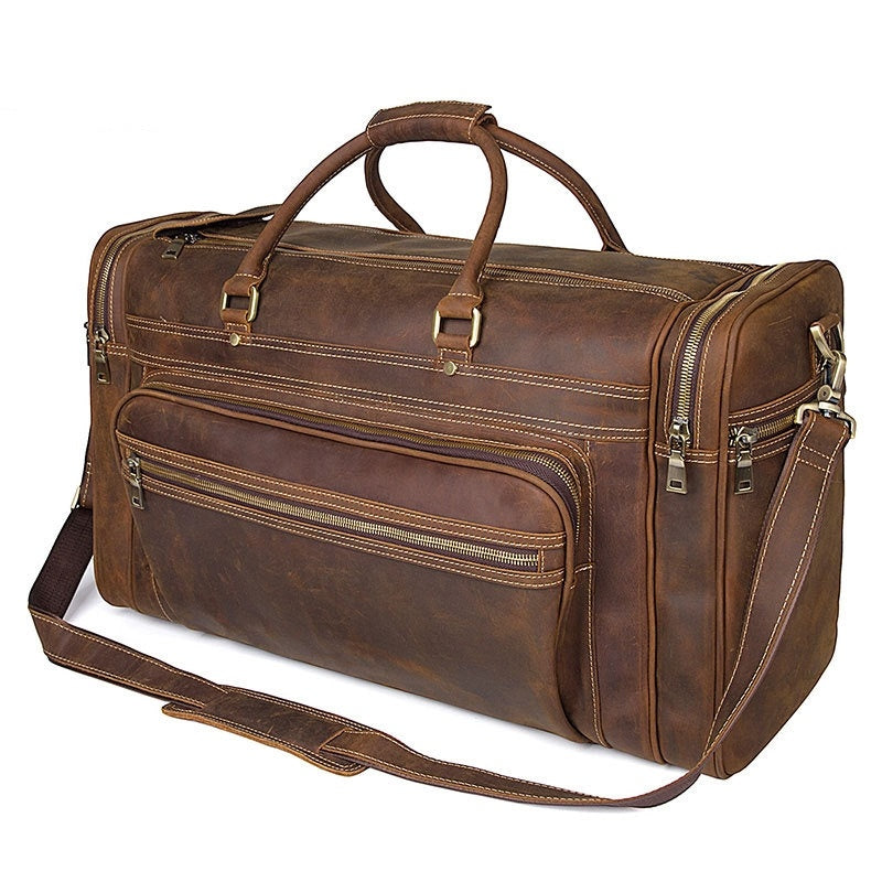 Brown leather duffel bag with multiple zippers on a white background