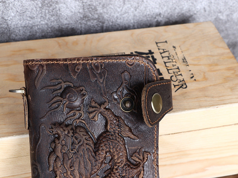 Brown leather wallet with embossed design on a wooden surface