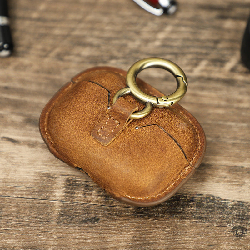 Brown leather keychain with brass ring on a wooden surface