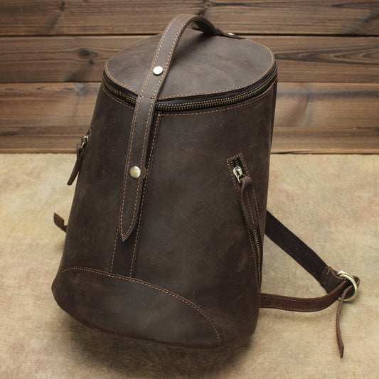 Brown leather backpack on a wooden floor