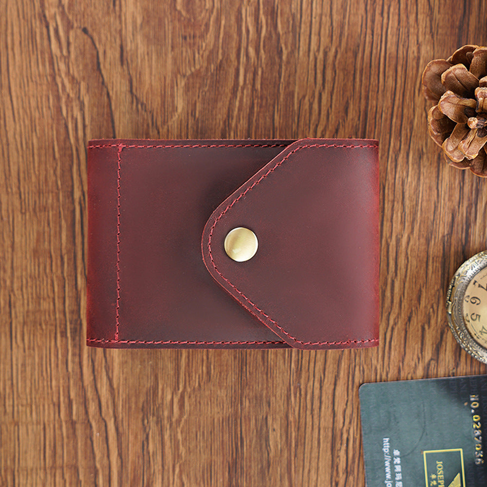 Brown leather wallet with a button on a wooden surface