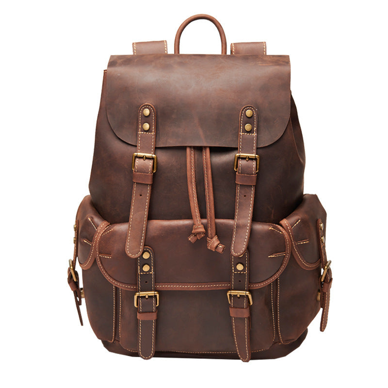 Brown leather backpack with gold buckles on a white background