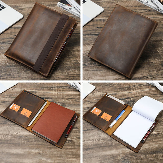 Brown leather notebook cover with pen holder on a wooden surface