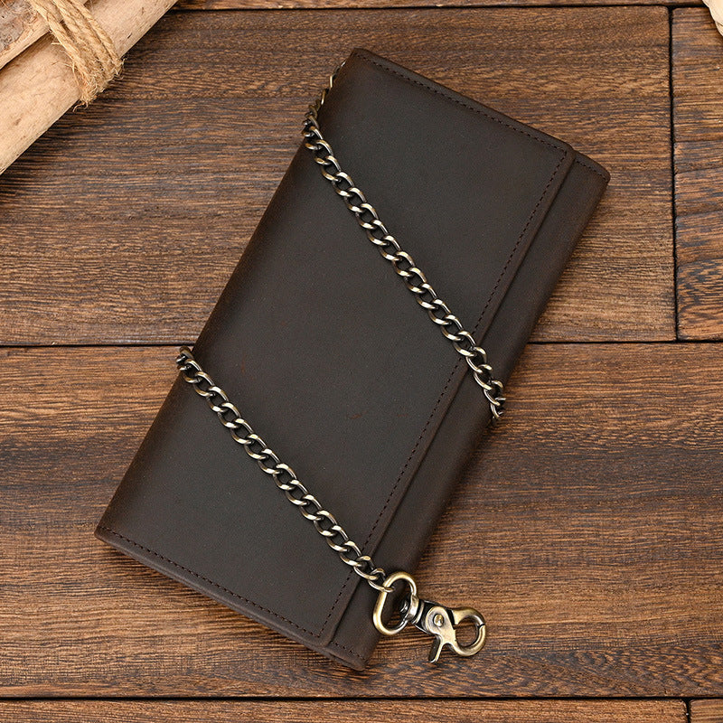 Brown leather wallet with chain on a wooden surface
