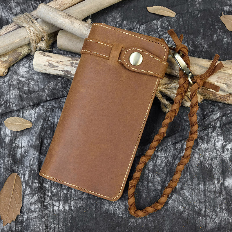 Brown leather phone case with a strap on a textured surface