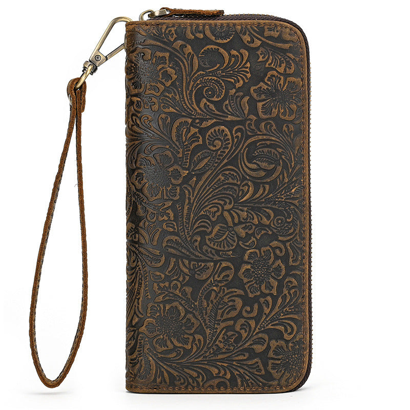Brown leather wallet with intricate floral pattern on a white background