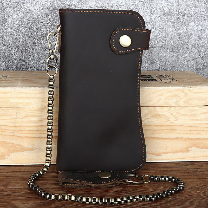 Black leather wallet with chain strap on a wooden surface