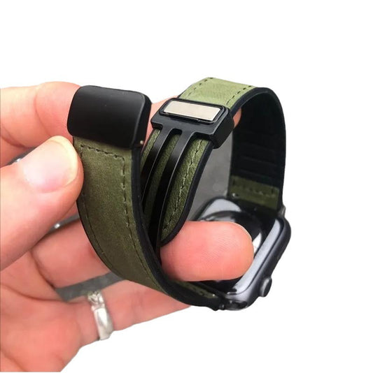 Hand holding a green and black watch strap against a white background