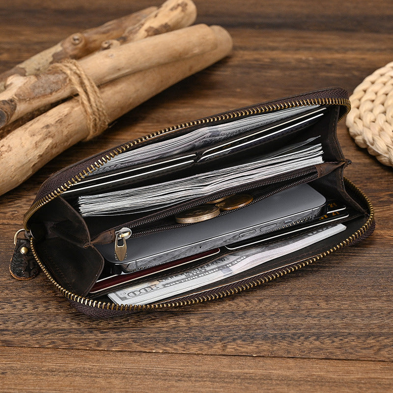 Open brown leather wallet with compartments on a wooden surface