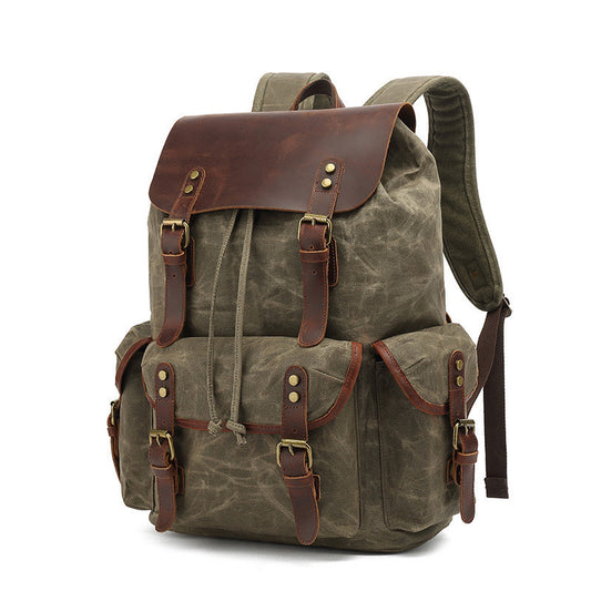 Waxed canvas backpack with leather straps on a white background