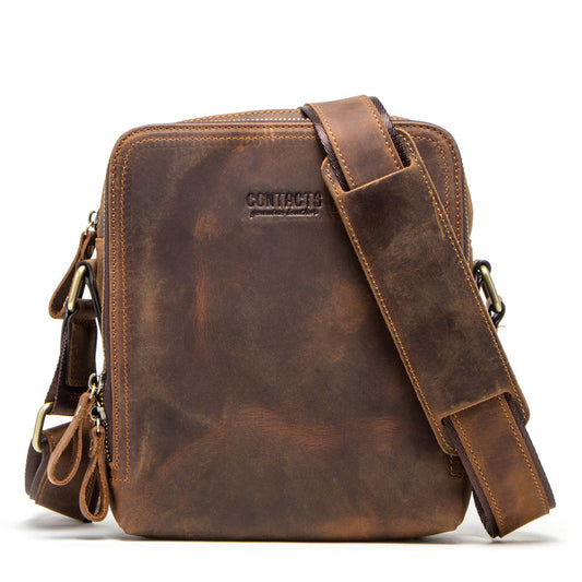 Brown leather crossbody bag with visible brand name on a white background