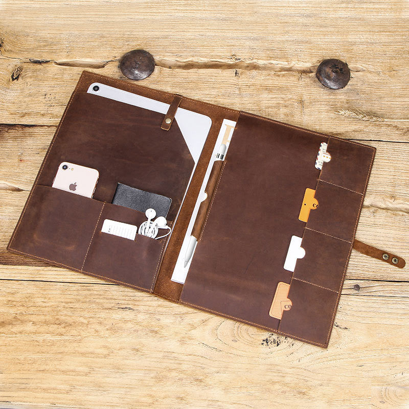 Brown leather portfolio with multiple pockets on a wooden surface
