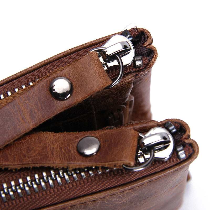 Close-up of a brown leather wallet with silver zippers on a white background