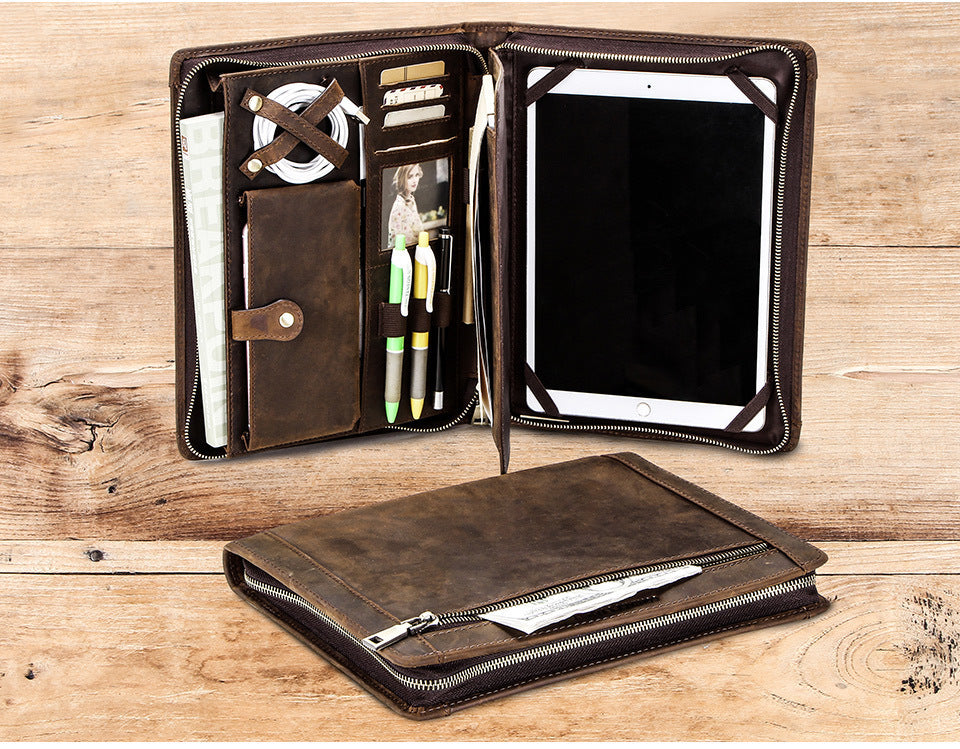 Brown leather portfolio with compartments on a wooden surface
