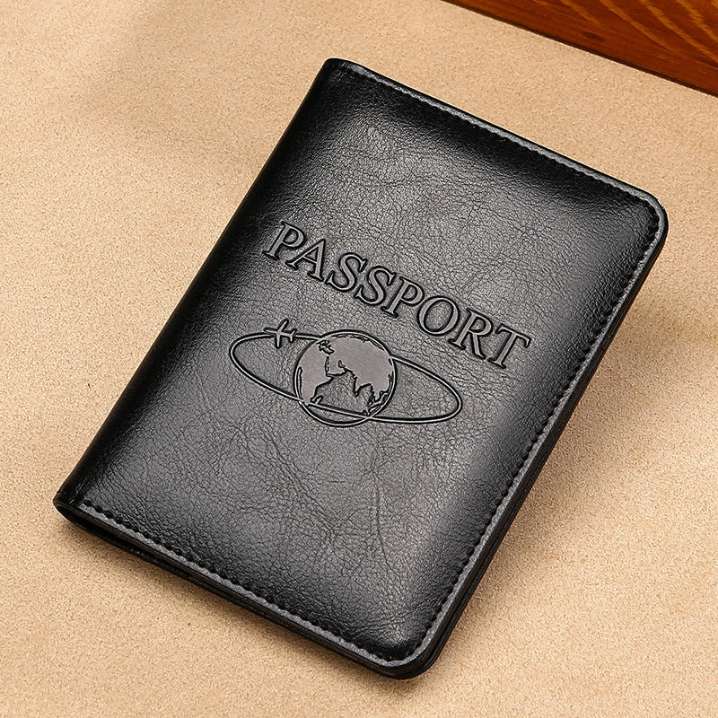 Black leather passport holder with 'PASSPORT' embossing on a beige surface