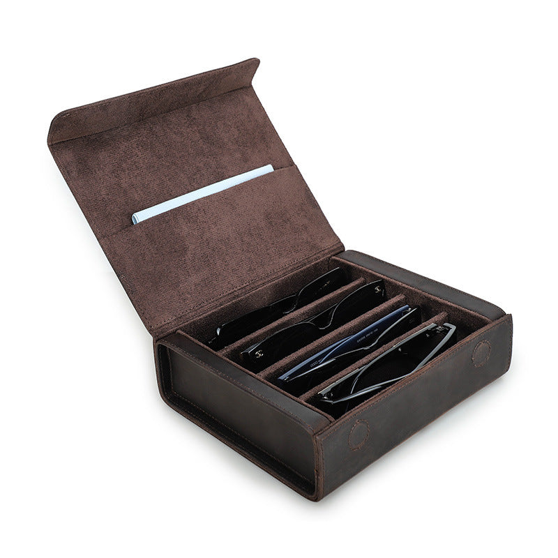 Open brown leather case with sunglasses inside on a white background