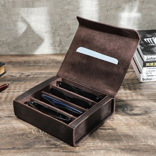 Brown leather case with compartments on a wooden surface
