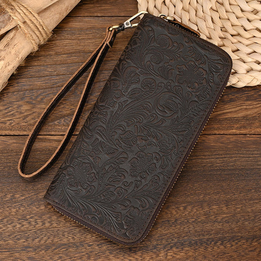 Brown leather wallet with embossed design on a wooden surface
