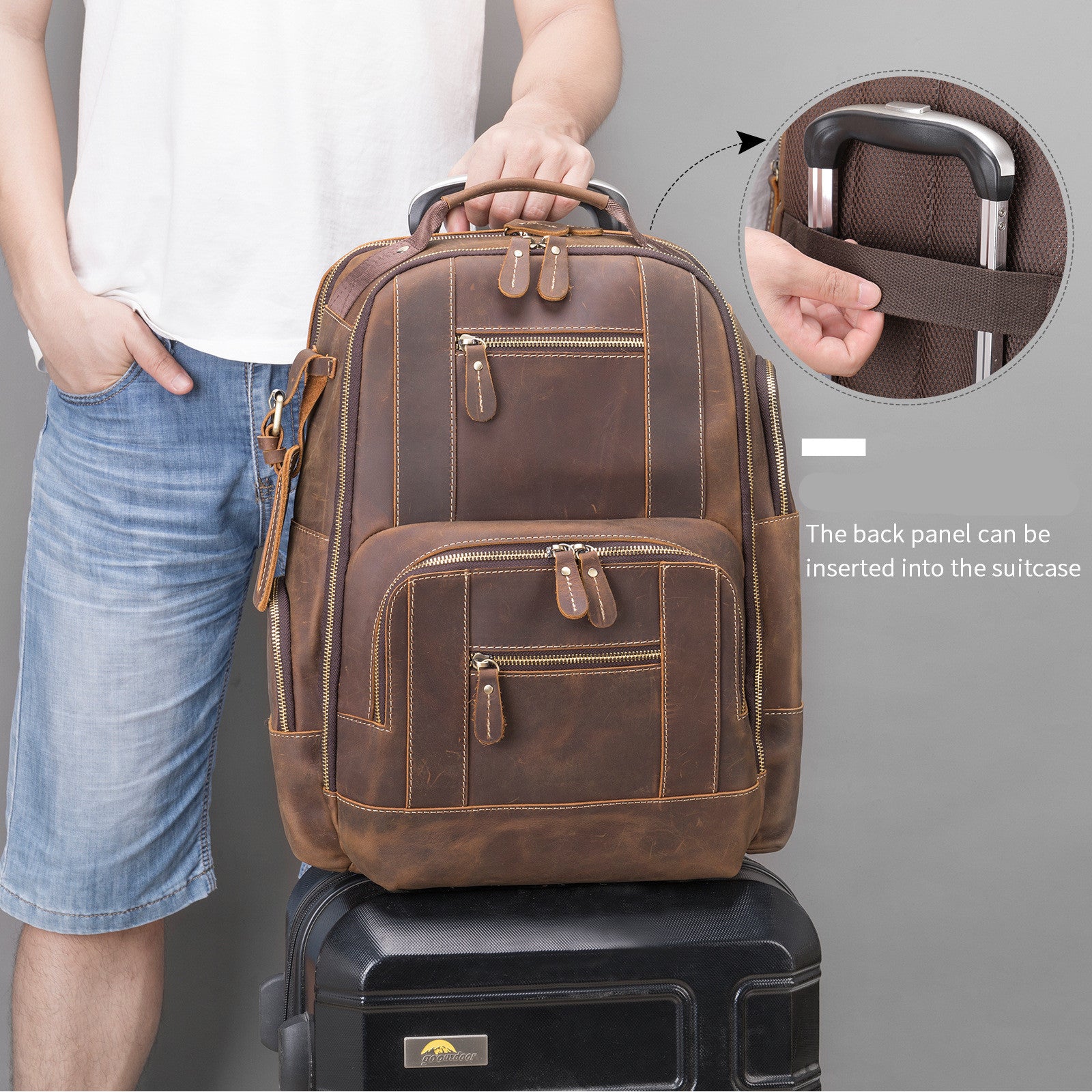 Brown leather backpack with suitcase attachment feature, person holding it.