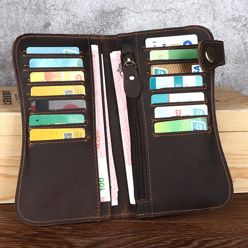 Brown leather wallet with card slots and money compartments on a wooden surface.