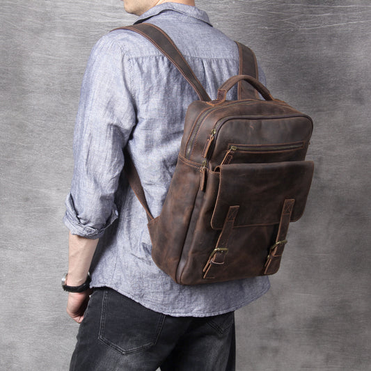 Person wearing a brown leather backpack against a gray background