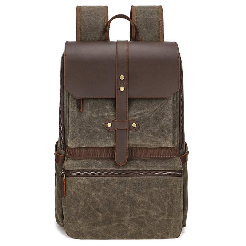 Brown waxed canvas backpack with leather accents on a white background