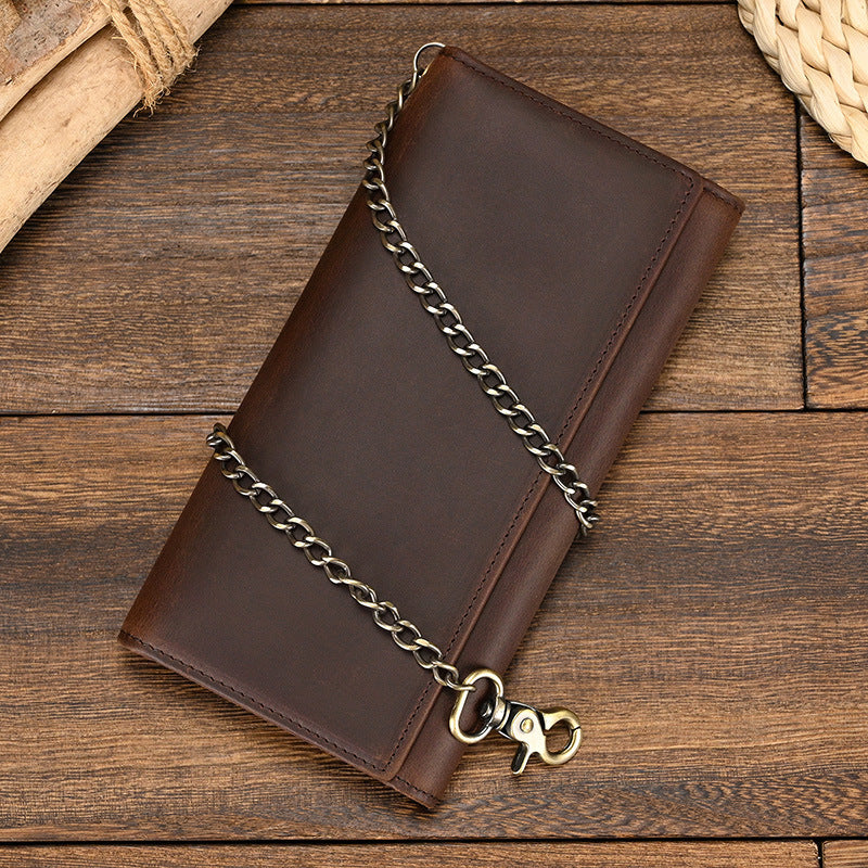 Brown leather wallet with chain on a wooden surface