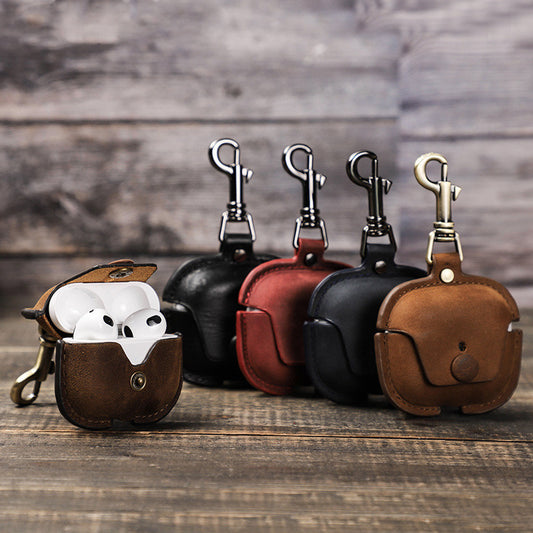 Set of leather keychains with attached pouches on a wooden surface