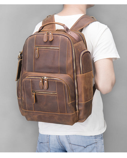 Person wearing a brown leather backpack against a gray background