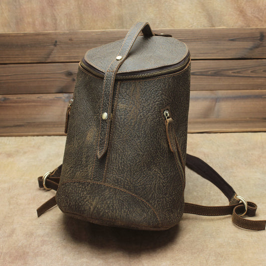 Brown leather backpack on a wooden floor
