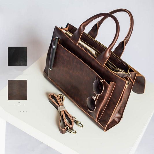 Brown leather handbag with sunglasses on a white surface