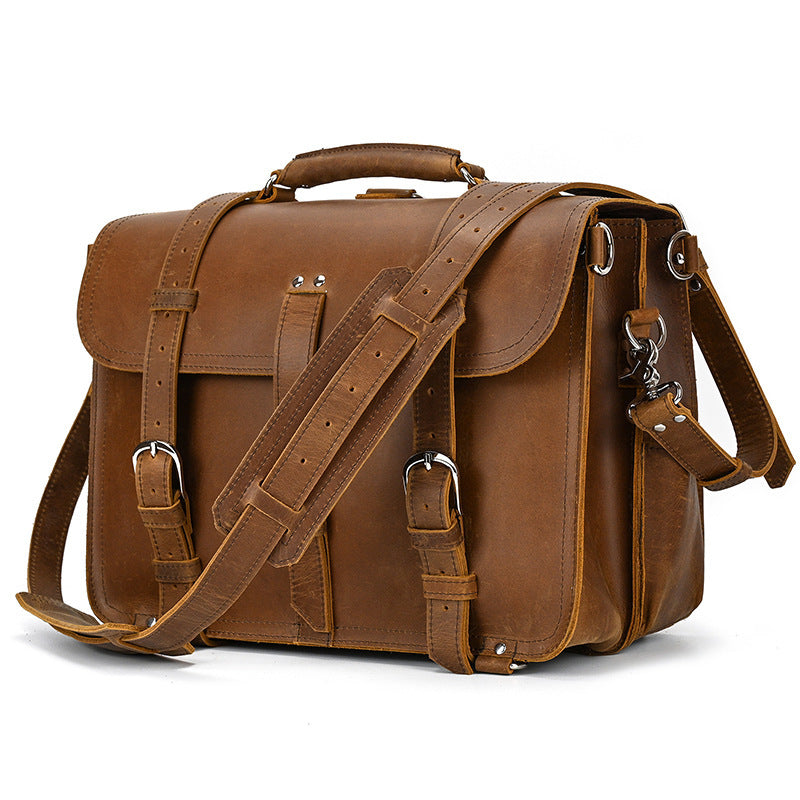 Brown leather satchel bag with shoulder strap on a white background