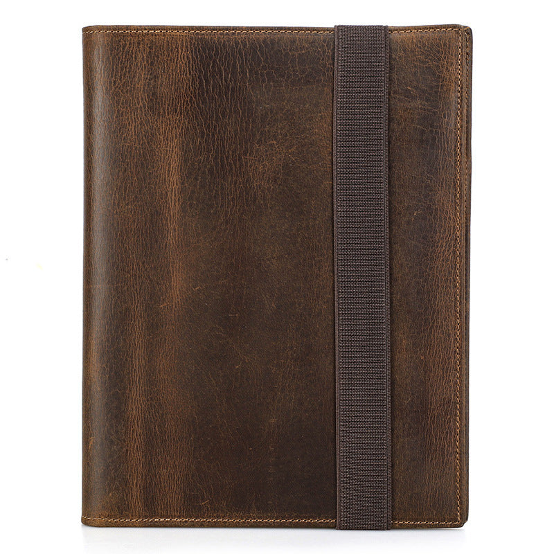 Brown leather-bound notebook with a strap on a white background