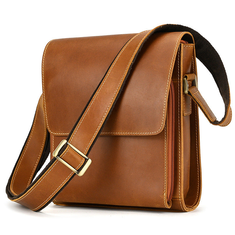 Brown leather satchel bag with a gold buckle on a white background