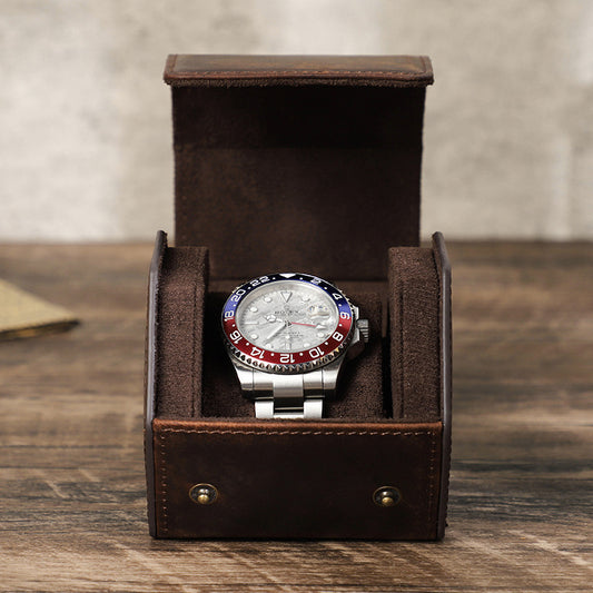 Watch with a colorful face in a brown leather box on a wooden surface