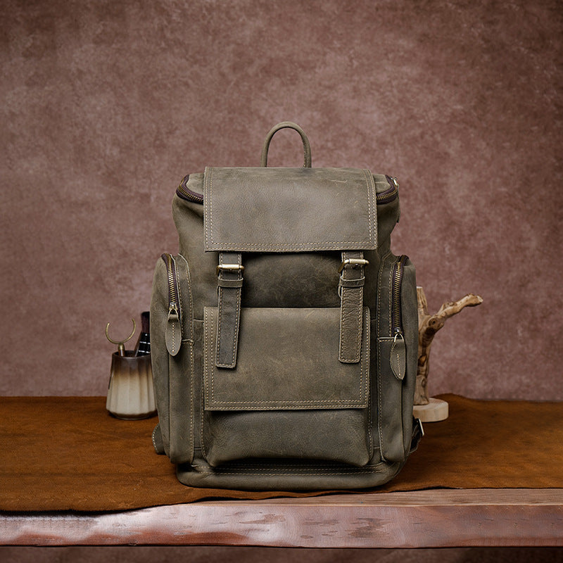 Green leather backpack on a wooden surface with a brown background
