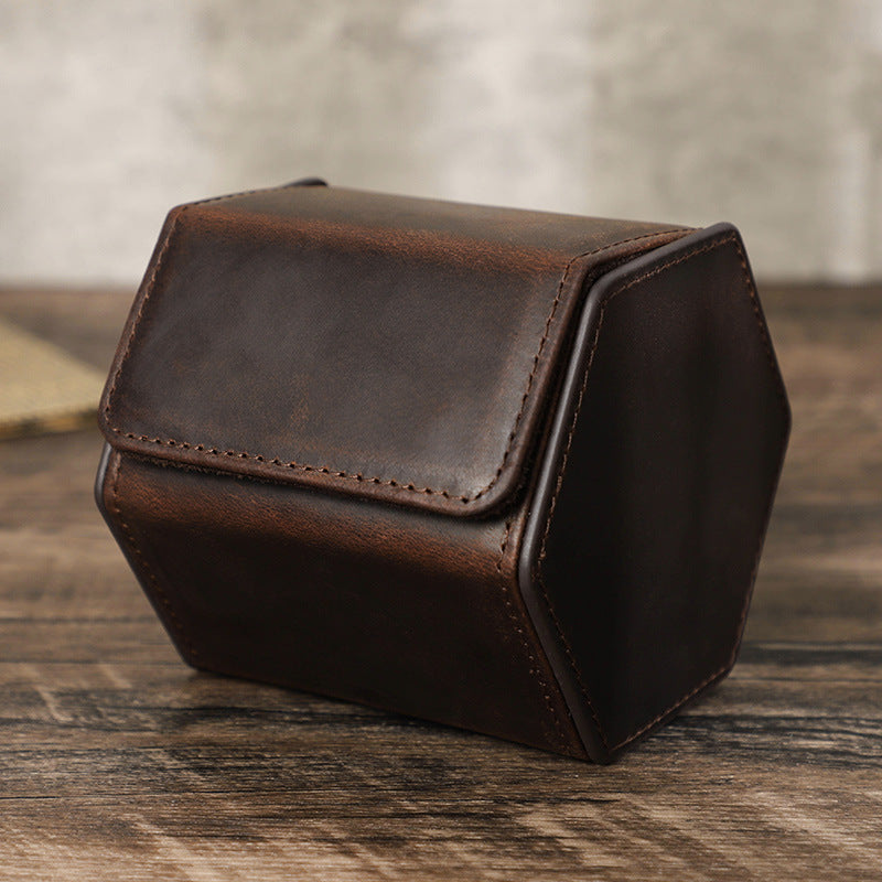 Brown leather jewelry box on a wooden surface with a blurred background