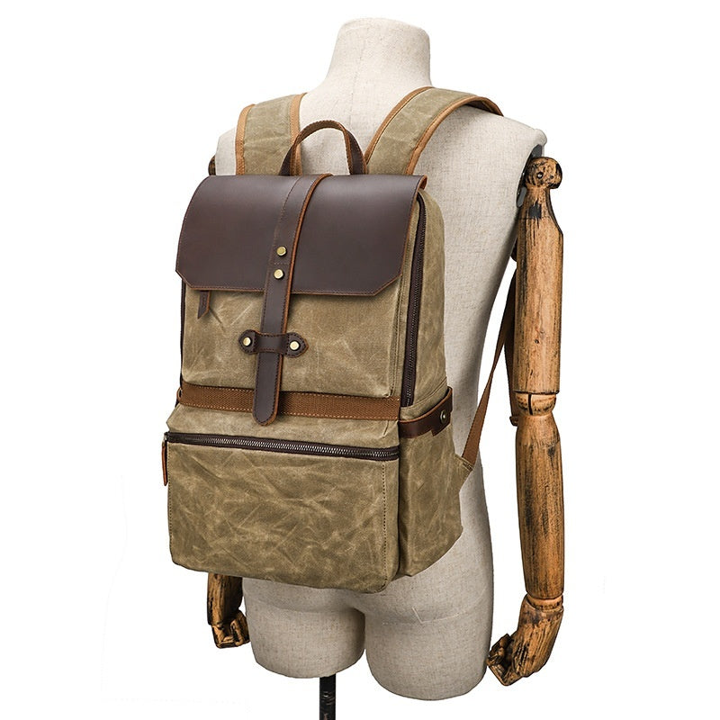 Brown leather and canvas backpack on a mannequin with a white background
