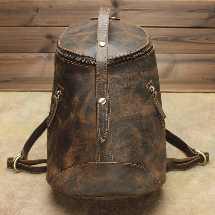 Brown leather backpack on a wooden floor