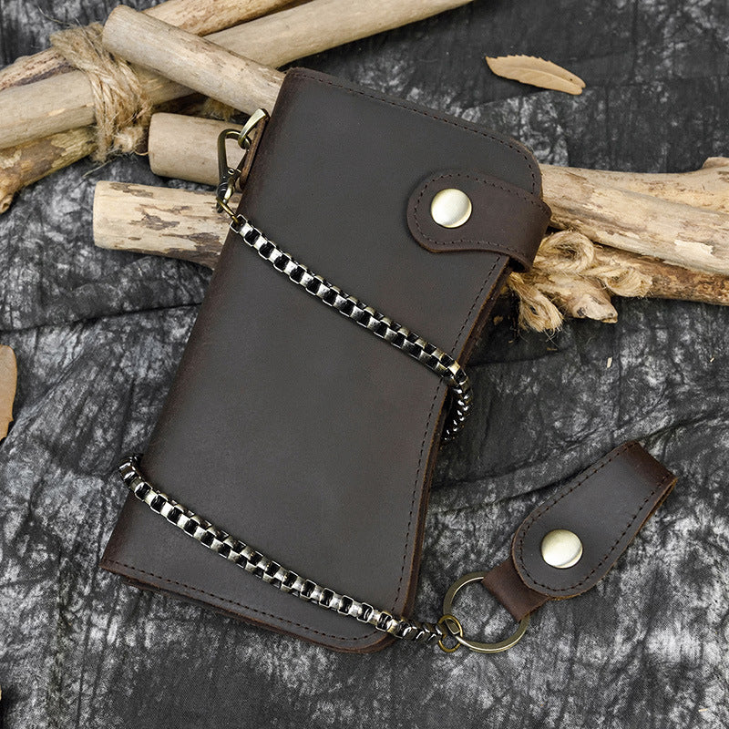 Brown leather wallet with chain on a textured surface